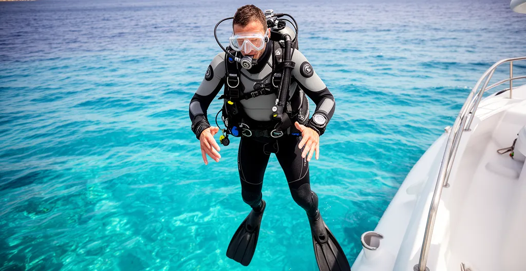 Plongeur équipé d'un gilet stabilisateur s'immergeant depuis un bateau en Méditerranée